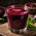 Glass of fresh beetroot juice with whole beets on a rustic table.