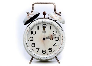 Rustic vintage alarm clock with weathered finish.