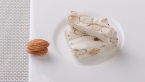 Almond nougat bars on a white plate.