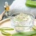 Aloe vera gel in a glass bowl with fresh aloe leaves.