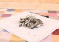 Dried small fish on a pastel tablecloth, ready for cooking.