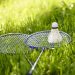 Badminton rackets and shuttlecock resting on grass.