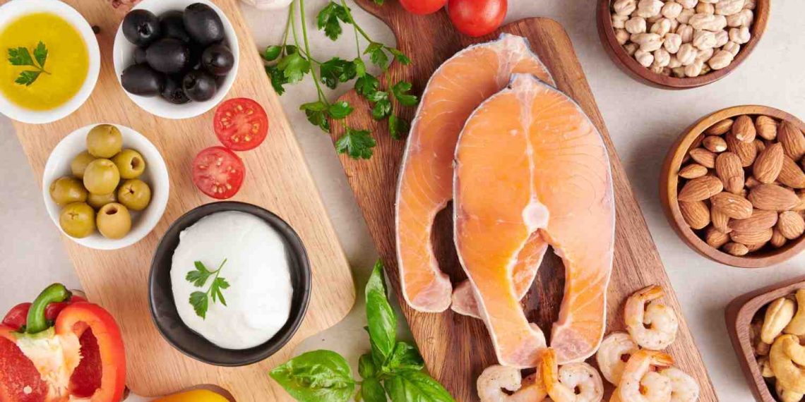 Salmon fillets with shrimp, vegetables, olives, and almonds on wooden boards.