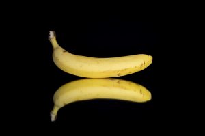 Banana with reflection on black background.