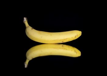 Banana with reflection on black background.