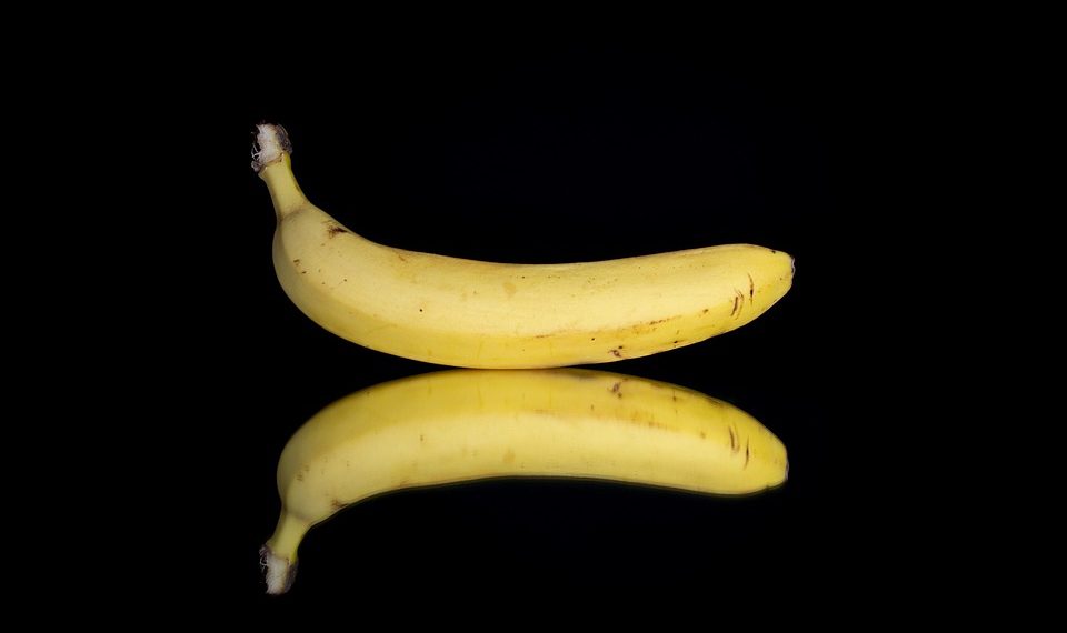 Banana with reflection on black background.