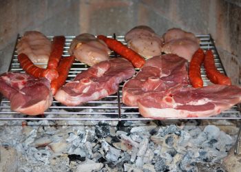 Grilling assorted meats over hot coals.
