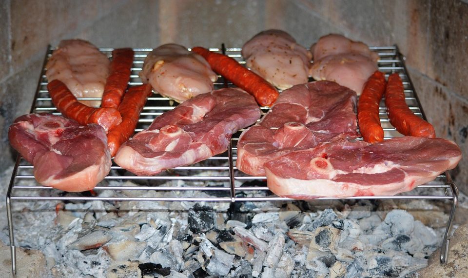 Grilling assorted meats over hot coals.