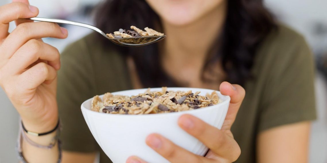 Eating a bowl of cereal topped with chocolate shavings.