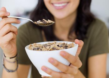 Eating a bowl of cereal topped with chocolate shavings.