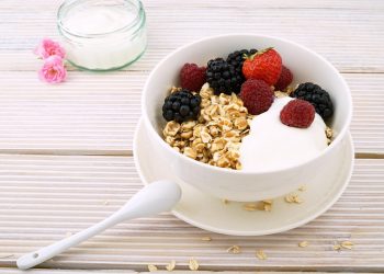 Yogurt bowl with granola, strawberries, raspberries, and blackberries.