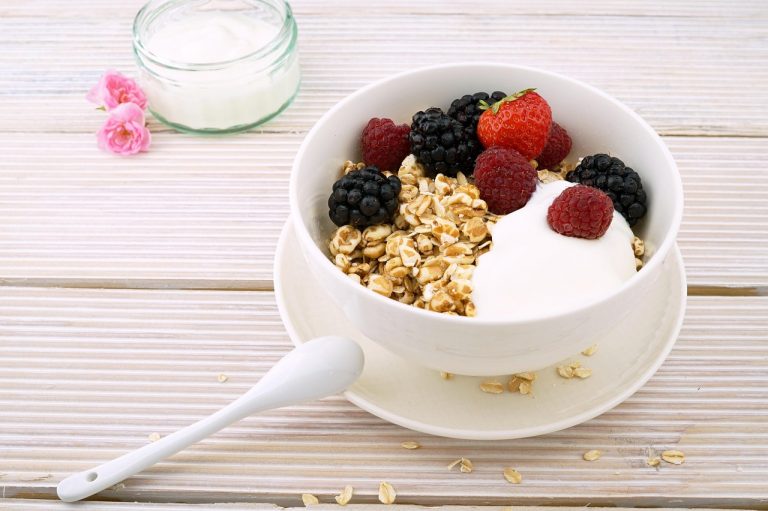 Yogurt bowl with granola, strawberries, raspberries, and blackberries.