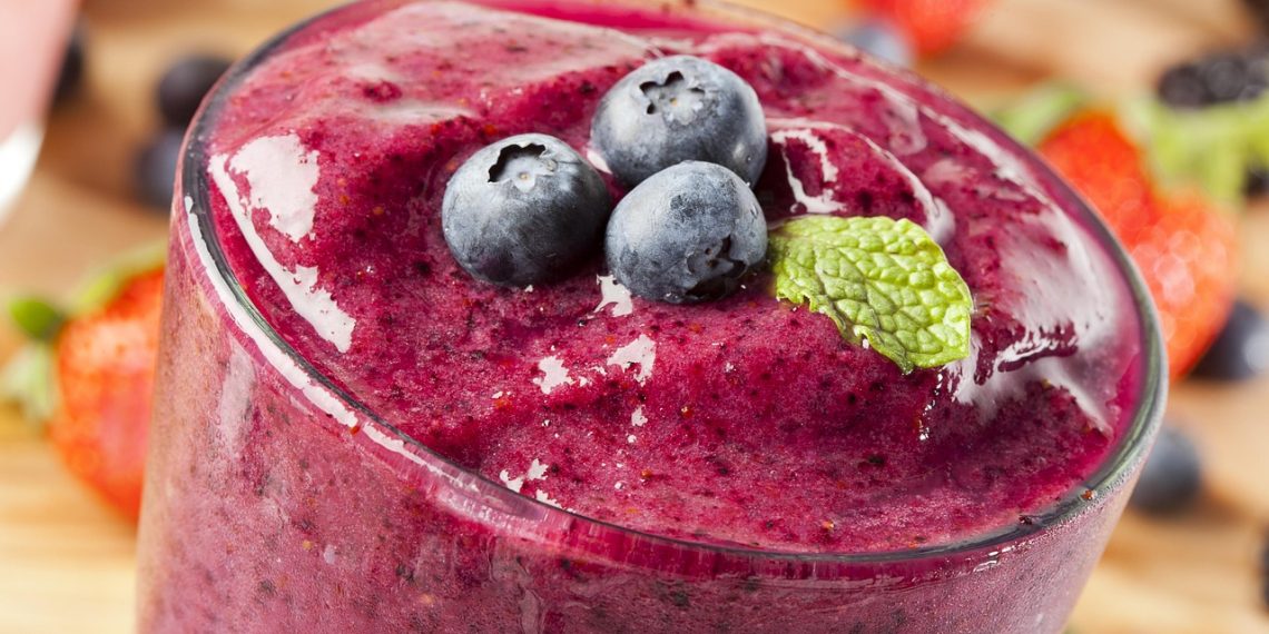 Blueberry smoothie topped with fresh blueberries and mint.