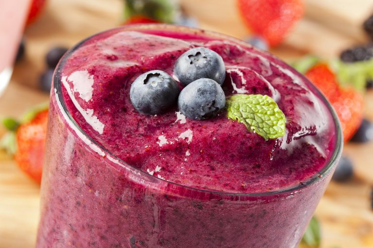 Blueberry smoothie topped with fresh blueberries and mint.