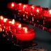 Red votive candles glowing in a dimly lit room.