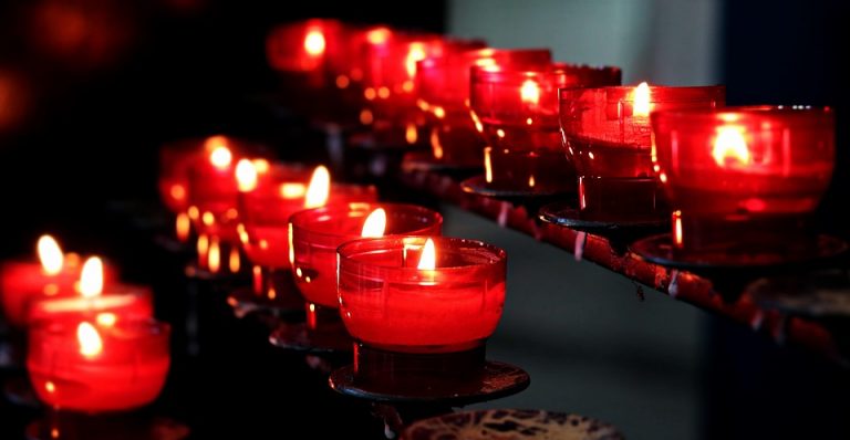 Red votive candles glowing in a dimly lit room.