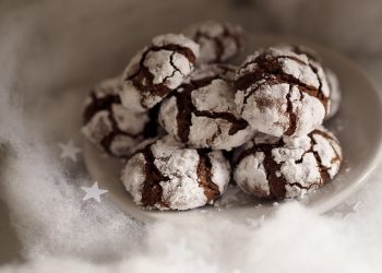 Chocolate crinkle cookies dusted with powdered sugar on a plate.