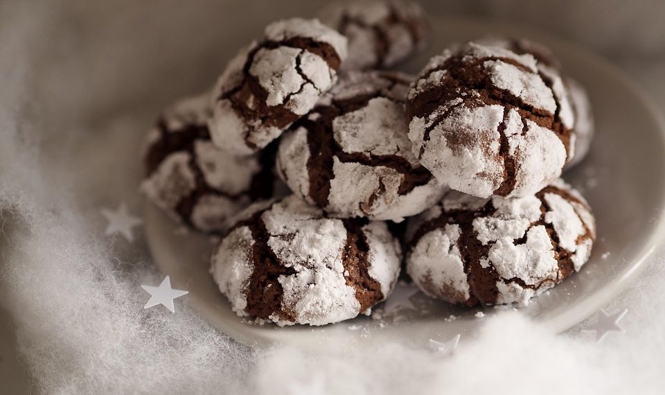 Chocolate crinkle cookies dusted with powdered sugar on a plate.