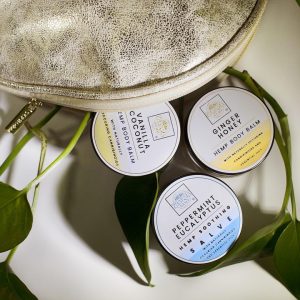 Hemp body balms with natural ingredients in a pouch.