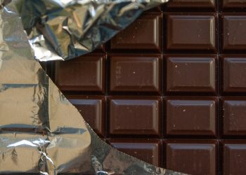 Bar of chocolate partially wrapped in foil.