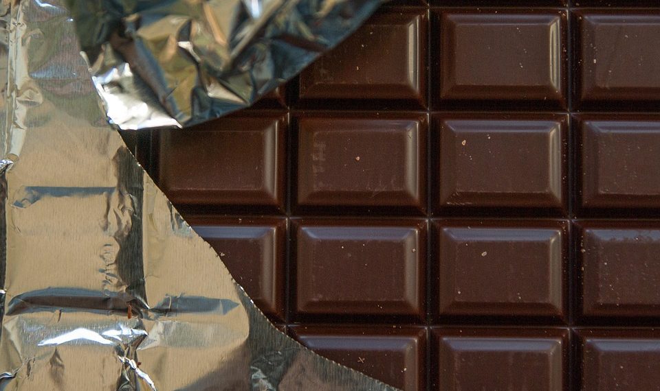 Bar of chocolate partially wrapped in foil.