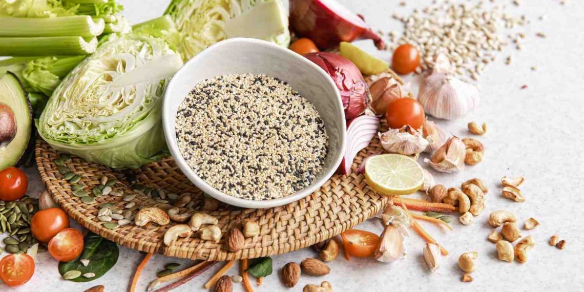 Fresh vegetables, seeds, and nuts on a woven mat.