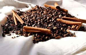 Cinnamon sticks and coffee beans arranged on cloth