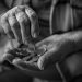 Elderly person counting coins in their hands.