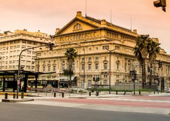 Historic theater building under a sunset sky in Buenos Aires.