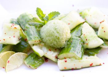 Cucumber salad garnished with a mint sorbet and lime slices.