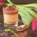 Chocolate mousse with raspberries and mint garnish in a glass cup.