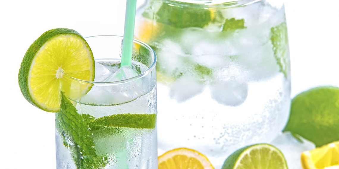 Glass of lemon-lime water with mint and ice cubes.