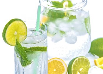 Glass of lemon-lime water with mint and ice cubes.