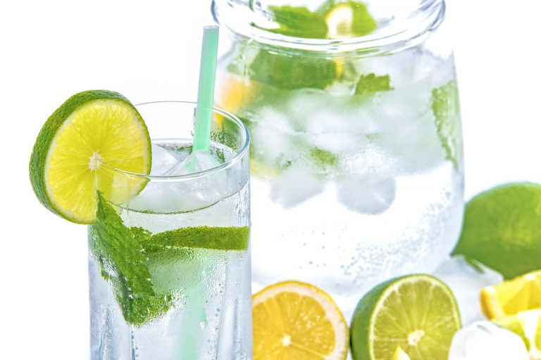 Glass of lemon-lime water with mint and ice cubes.