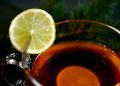 Cup of tea with lemon slice on rim, aromatic hot drink.