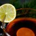Cup of tea with lemon slice on rim, aromatic hot drink.