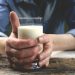 Hands holding a glass of fresh milk.