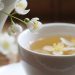 Jasmine tea in a white cup with fresh flowers.