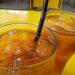 Two glasses of iced tea on a yellow table.
