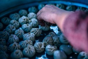 Hand selecting freshly steamed dumplings.