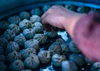 Hand selecting freshly steamed dumplings.