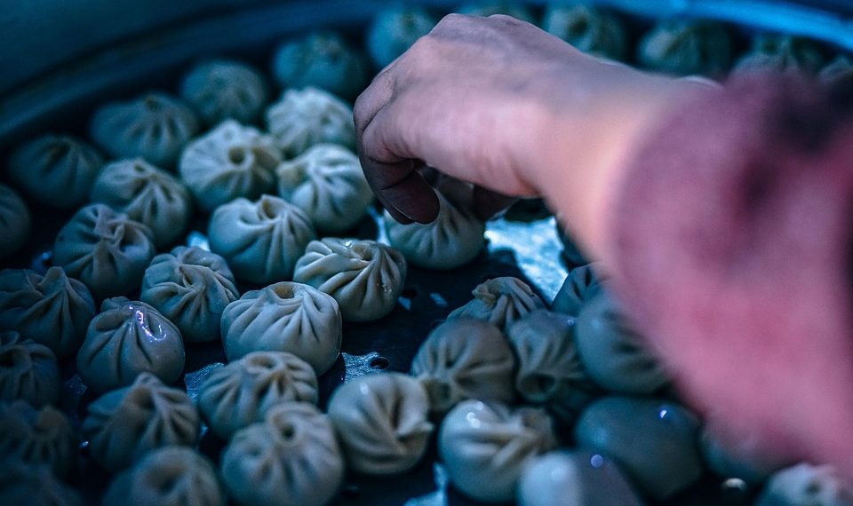 Hand selecting freshly steamed dumplings.