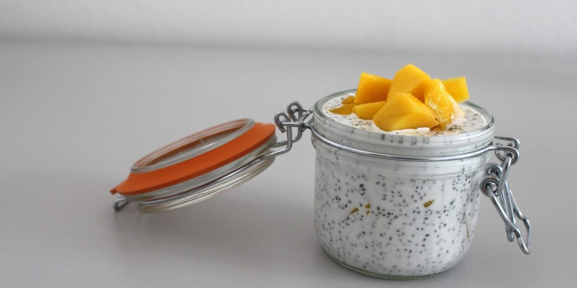 Chia pudding topped with fresh mango cubes in a glass jar.