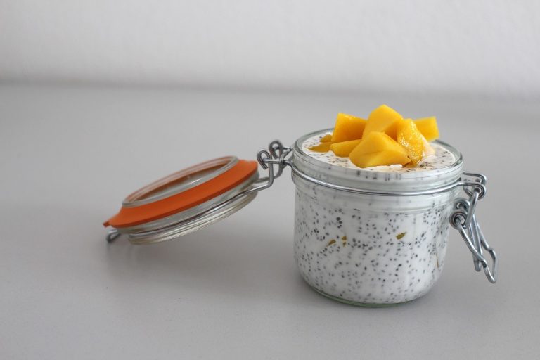 Chia pudding topped with fresh mango cubes in a glass jar.