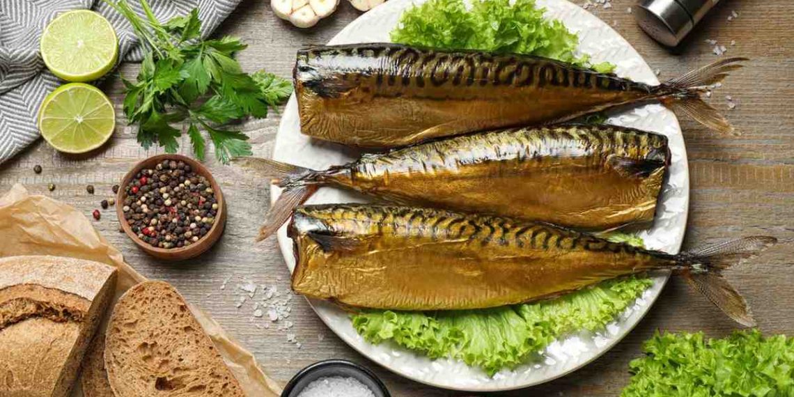 Smoked mackerel on a plate with herbs, bread, and spices.