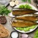 Smoked mackerel on a plate with herbs, bread, and spices.