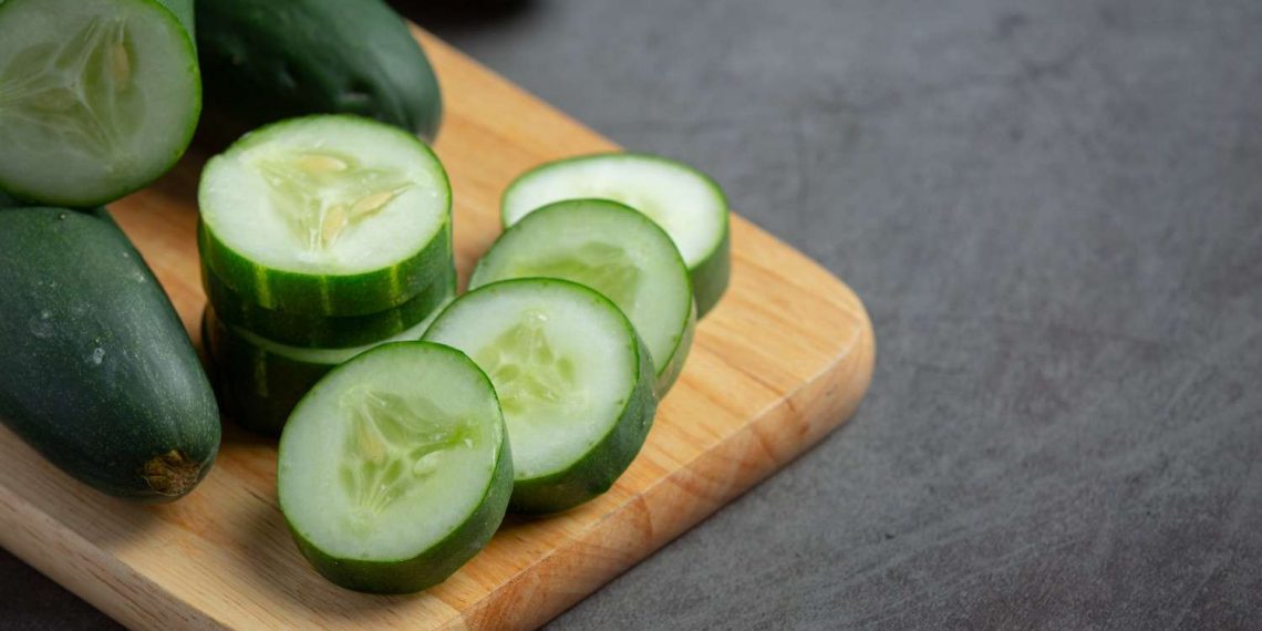 Sliced cucumber on wooden board, fresh and ready for salads.