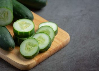Sliced cucumber on wooden board, fresh and ready for salads.