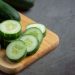 Sliced cucumber on wooden board, fresh and ready for salads.