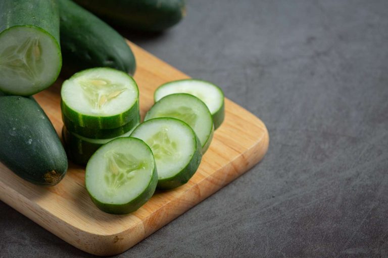 Sliced cucumber on wooden board, fresh and ready for salads.